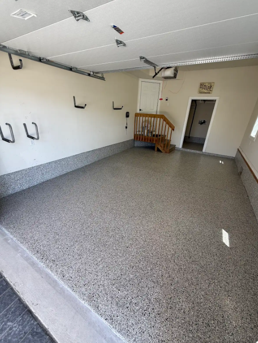 Finished garage with a gray, white and black decorative flake epoxy floor coating and cove base