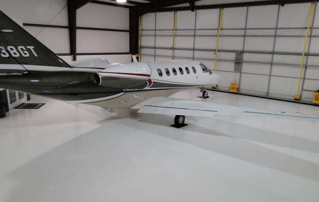 Bright white high-gloss epoxy floor inside an aircraft hangar