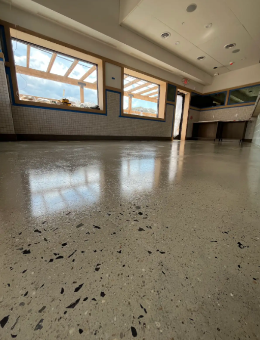 Terrazzo-style polished concrete floor in a bright commercial space
