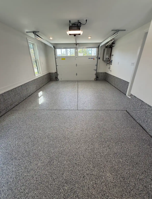 Glossy gray and black flake epoxy floor in a clean residential two-car garage