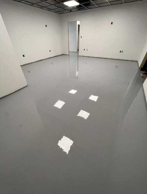 Mirror-finish self-leveling solid gray epoxy floor in an empty commercial suite