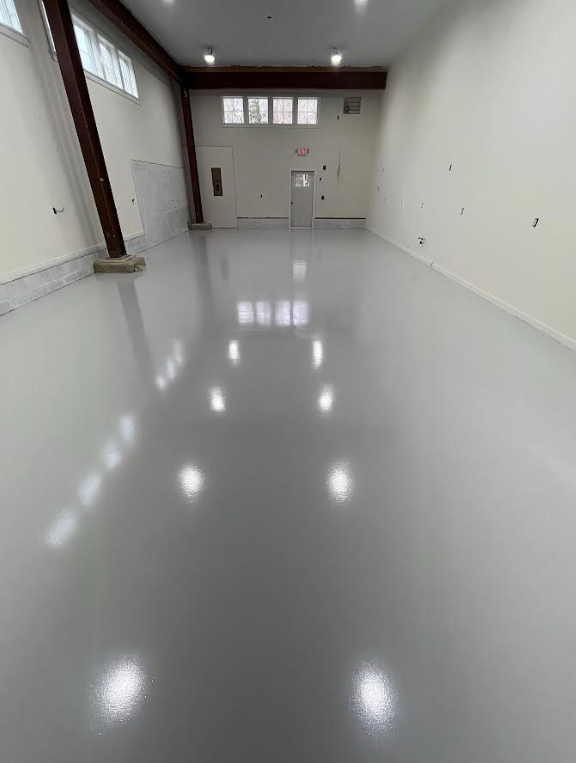 Large bright room with a finished solid gray high-gloss epoxy floor coating