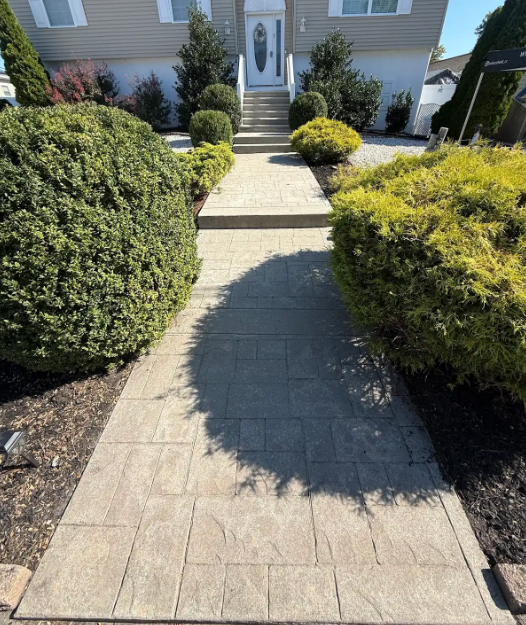 Weathered, dull paver walkway leading to a house before stain and seal treatment